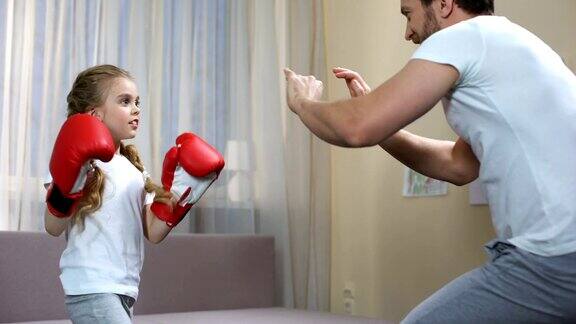 父亲在家里训练女儿打拳击花时间在一起训练