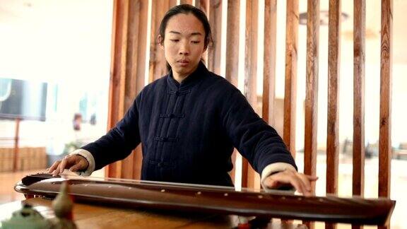 在太极学校弹奏古琴的亚洲男子