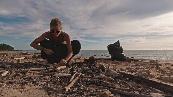 女性生态游客在日落海滩捡到微塑料
