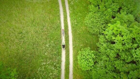 鸟瞰图上的男人和女人骑在泥土路在夏天的时间