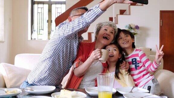 微笑的中国老人在家里与孙辈自拍