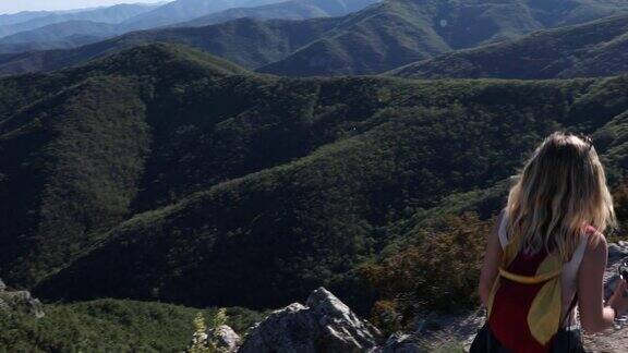 女性徒步登山欣赏沿途风景