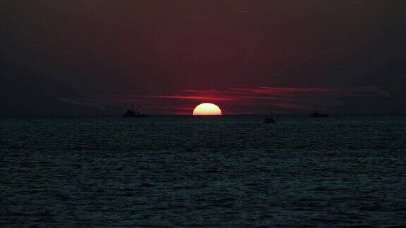 大海上的日出日落和船只的剪影