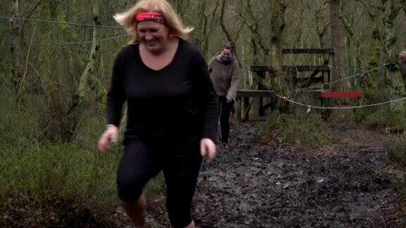 女子比赛泥跑通过林地-慢动作