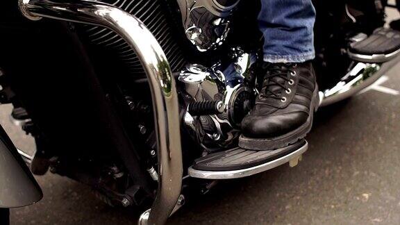 在摩托车上穿着靴子的脚夫的特写