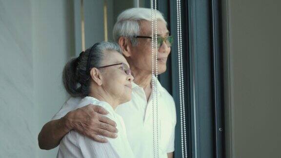 一对老夫妇在家享受时光的4k视频拥抱微笑福利退休夫妇肖像概念