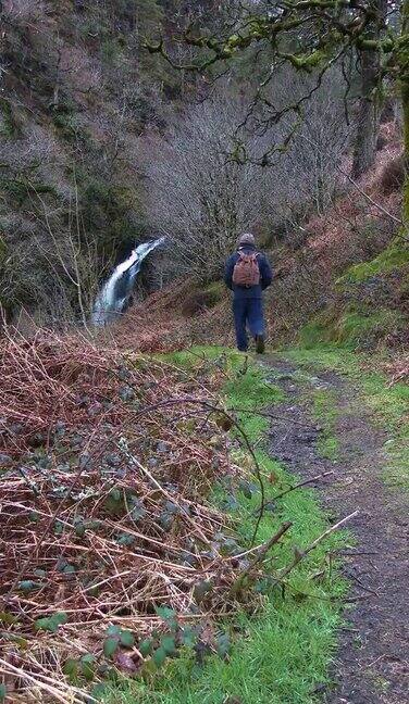 一个退休老人在瀑布附近散步