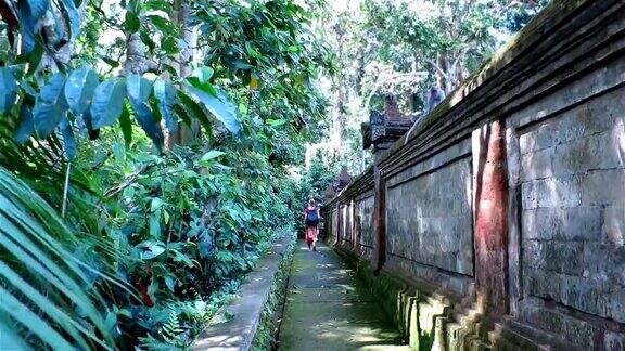 在巴厘岛乌布一名妇女走过神圣的猴子森林