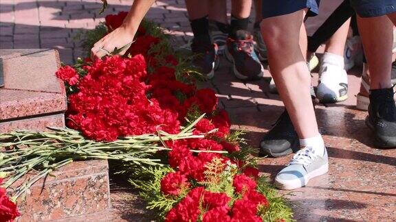 胜利日一队人在永恒火焰纪念碑前献花
