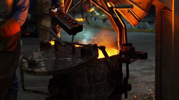 在铸造厂操作人员将熔化的金属从熔炉中挤出然后浇注到钢包中