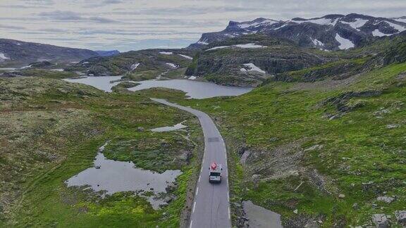 风景鸟瞰图露营车与红船在道路上通过挪威高地