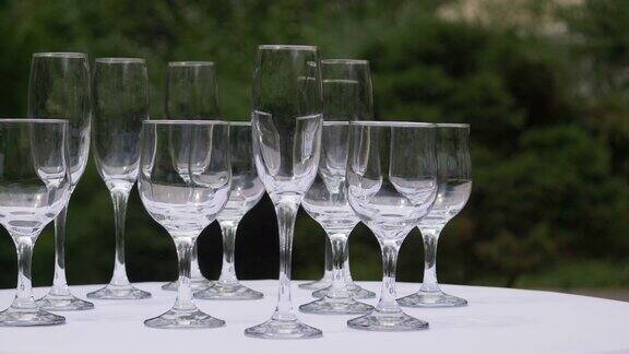 各种各样的杯子排列在一张桌子上等待斟满饮料的移动画面