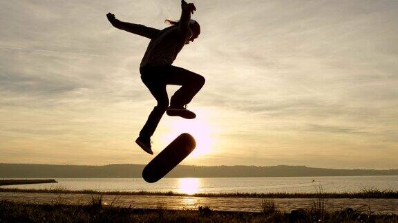 慢动作滑板溜冰和跳跃kickflip技巧在夕阳之上