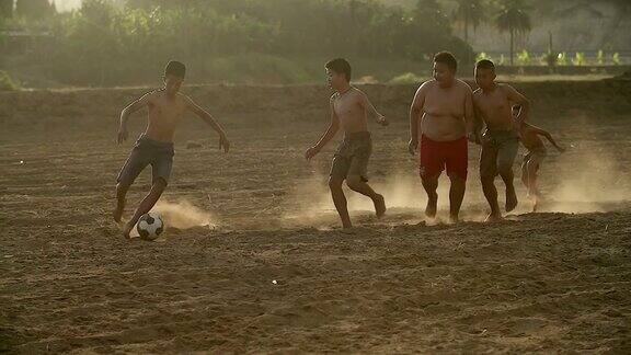 慢镜头农村的孩子们在阳光明媚的日子里踢足球