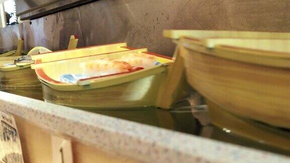 在传送带寿司店的寿司船上各种各样的寿司卷经过