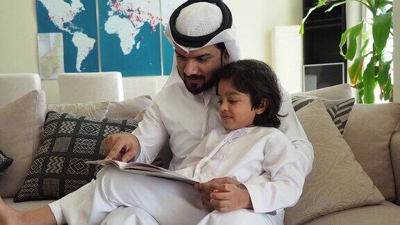 阿拉伯爸爸和儿子在家里看书做作业
