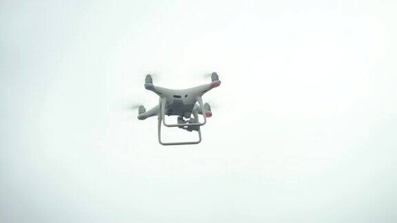一架白色的四旋翼飞行器在天空的映衬下飞向摄像机