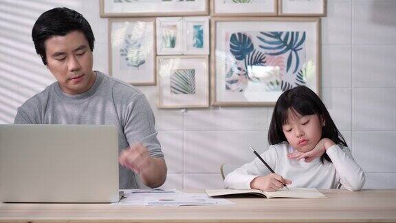 亚洲家庭的商人工作和学生女孩在家学习在互联网上父女愉快的表情与会议在线