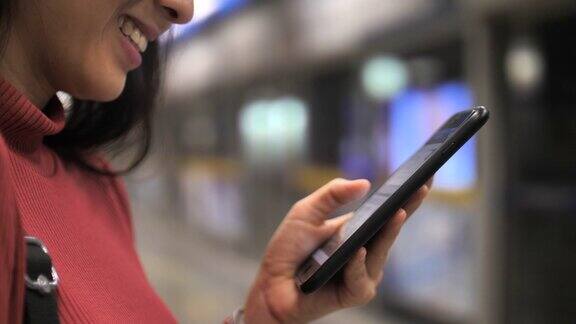 亚洲女性在地铁站使用智能手机