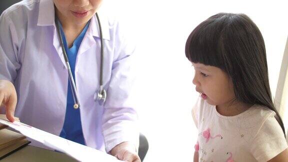 儿科医生在医院里和一个小女孩谈话