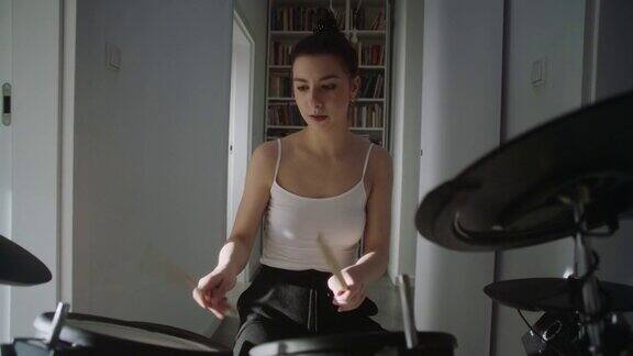 年轻女子在客厅里练习电子鼓