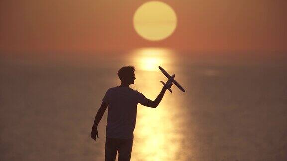 在夕阳的背景下这个人正在发射玩具飞机慢动作