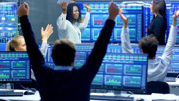 多族裔交易员团队在证券交易所办公室度过成功的一天交易商和经纪人在市场上买卖股票他们庆祝有利可图的交易显示器显示相关的信息图数据和数字