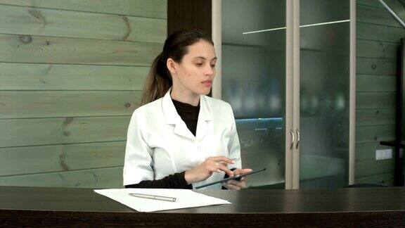 一位女士在水疗中心前台用平板电脑给客户发短信