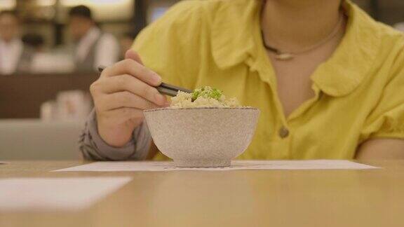 一个女孩在餐馆吃日本米饭