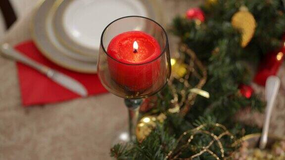 特写红色圣诞蜡烛与女性的手点燃火柴无法辨认的白人苗条年轻女子在家里准备浪漫的年夜饭在室内