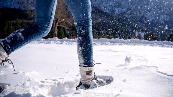 在白雪覆盖的山坡上穿雪鞋的女人