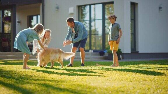 微笑的父亲女儿儿子与忠诚的金毛猎犬玩耍他跑向他们他们都拥抱那只美丽的纯种狗在阳光明媚的日子里一家人一起在户外玩慢动作