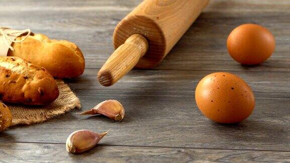木桌上放着长棍面包、鸡蛋和面粉