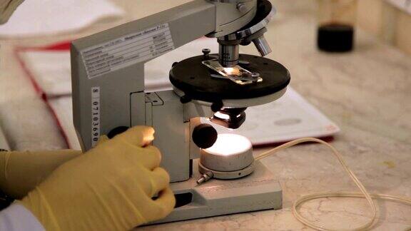 一个科学家在实验室里使用显微镜的特写