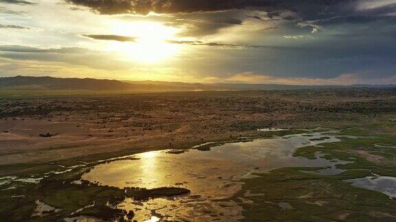 沙丘、白云戈壁和日落时的湖泊