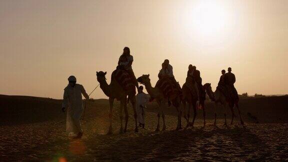 迪拜沙漠中骑骆驼的人们