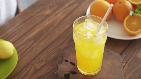 自制的柠檬水盛在盘子里的新鲜柠檬和橙子清凉的夏季饮料加冰在玻璃杯里