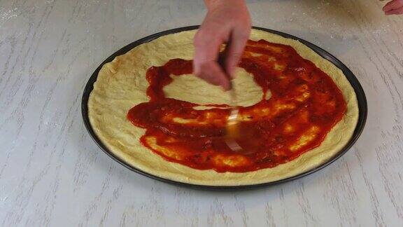 一个女人用勺子往生面团上倒披萨酱
