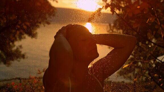 日落时分在海滩上洗澡的女人