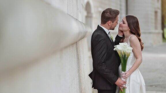 新婚夫妇捧着花束亲吻