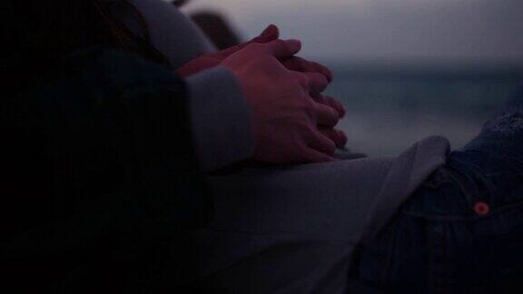 一对浪漫的情侣在海边拥抱、牵手