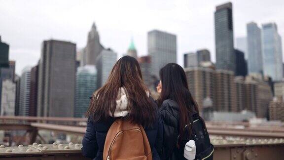 游客在布鲁克林大桥上观察曼哈顿下城
