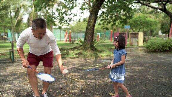 父亲教女儿打羽毛球