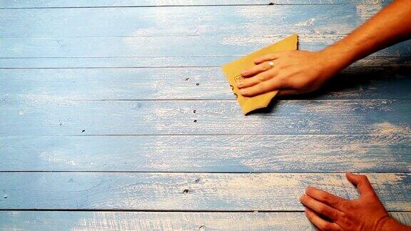 用砂纸打磨木板以使其看起来更旧的过程