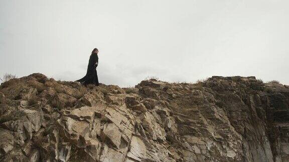 女孩走在悬崖边上穿着黑色的民族服装穿着丧服