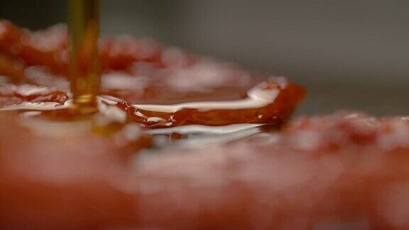 慢镜头:美味的橄榄油洒在腌西红柿上的模糊镜头