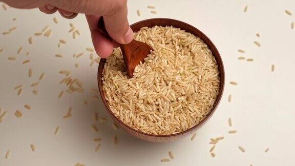 木碗里的干米饭长糙米旋转关闭了谷物倒了一堆世界危机出口进口收获问题制裁价格上涨和食品供应短缺
