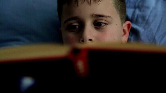 男孩在看书而不是在床上睡觉