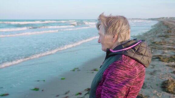 白发苍苍的女人从海边欣赏风景如画的海景