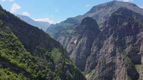 猛禽沿着峡谷中的岩石山飞行的鸟瞰图